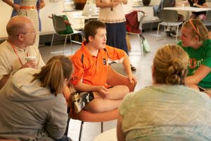 InclusiveU student sits with classmates in the commons