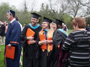 Master's students smile at graduation