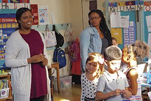 At The Neighborhood School in Manhattan, Dagmo Yusuf ’17 (left) guides first-graders while accompanied by their teacher, Chelsea Crawford.