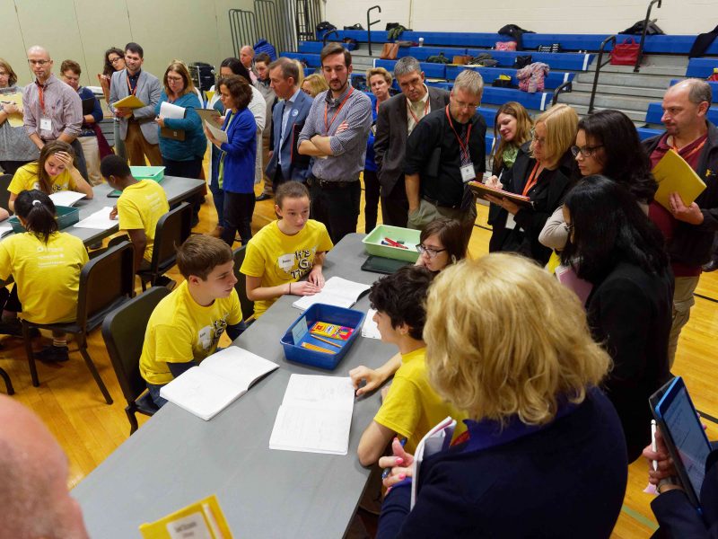 Students complete a science project as teachers observe