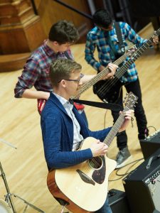 David Knapp plays guitar with New American All-Star students