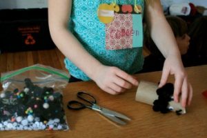 Child works with plastic eyes and felt at an eco art class