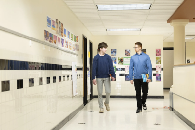 A teacher and student teacher ina school corridor