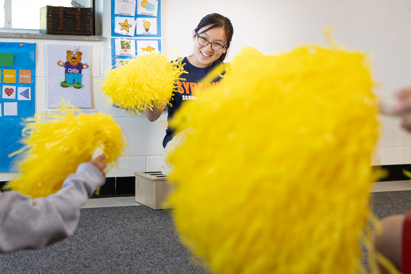 Emily Liu teaches a class with cheerleading pom-poms