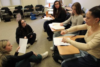 Students sit in a group signing ASL