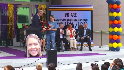 A teacher receives an award on stage
