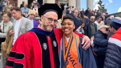 A professor and student in graduation regalia