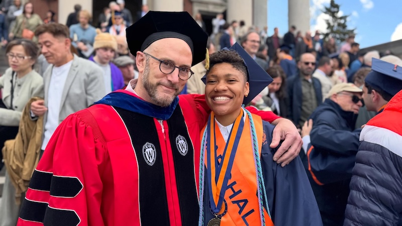 A professor and student in graduation regalia