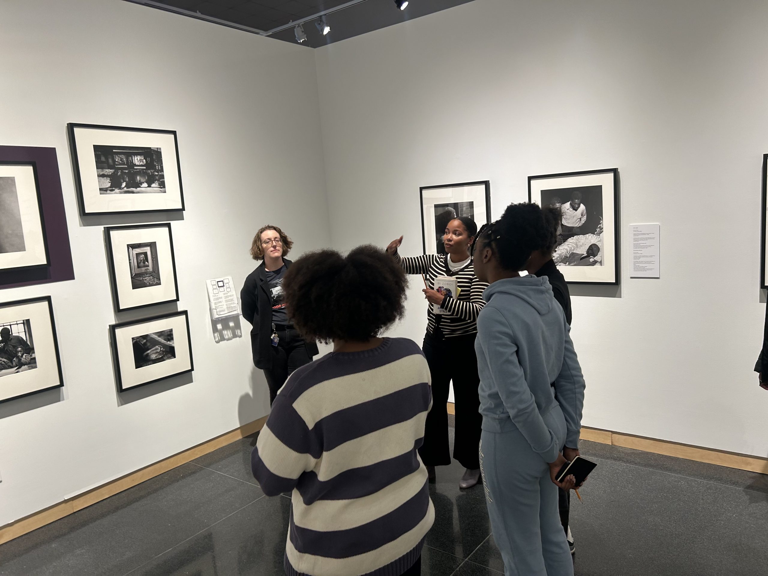 Students and a teacher look at art works in a museum
