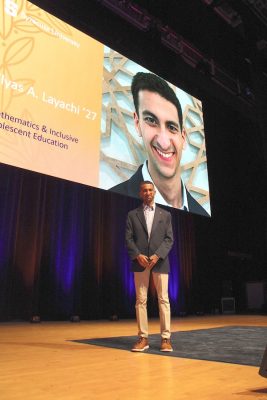 Elyas Layachi stands on a stage