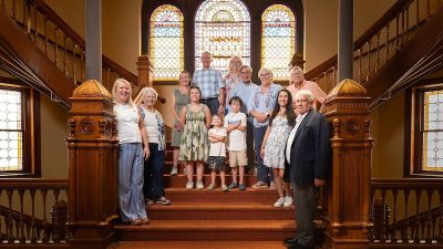 Generations of a family stand on a wooden staircase