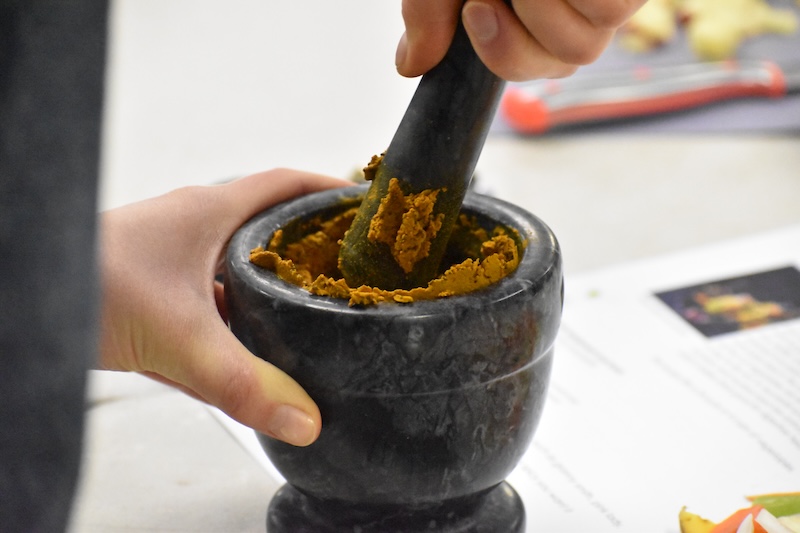 A spice mix being ground up in a pestle