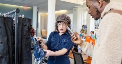 A VPA student shows her fashion designs to another student