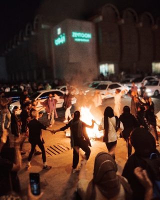 Women dancing around a bonfire