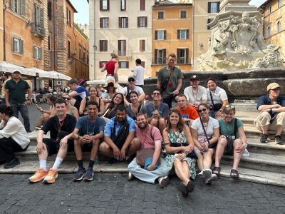 A group of students sitting on steps at a fountain