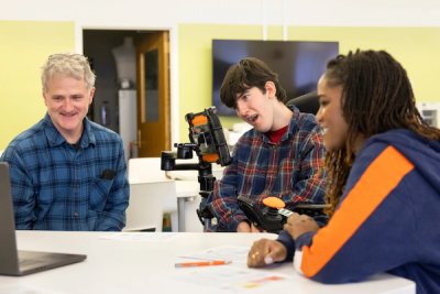 A disabled student looks at a compuyter screen along with two others.