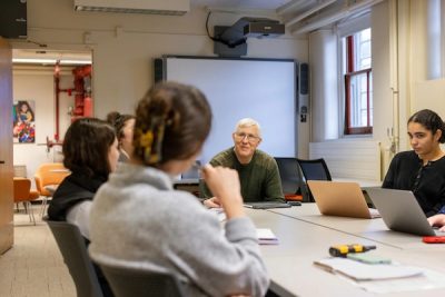 A teacher debriefs with students in a classroom