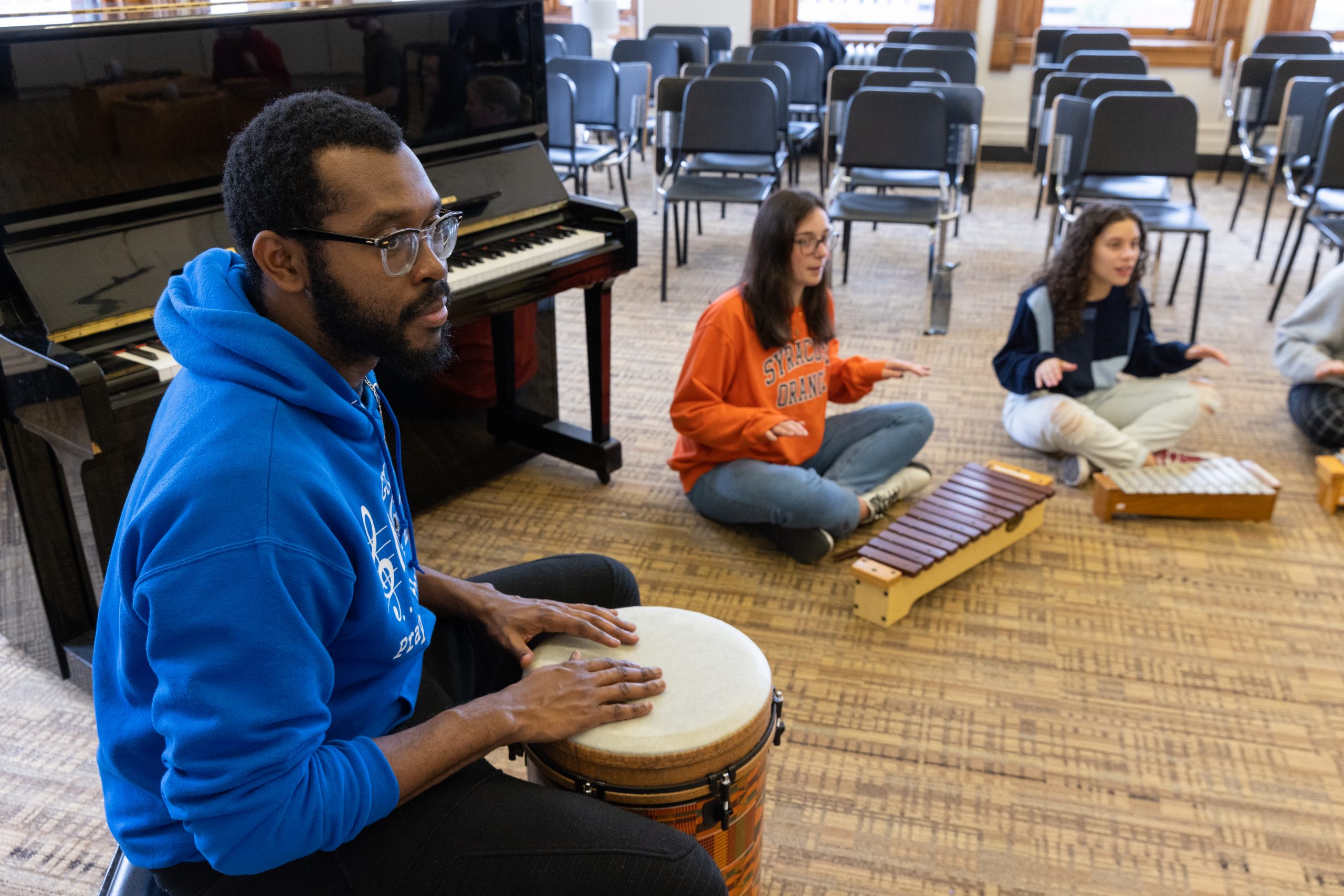 students play the drums, xylophone, and other instruments in a music education class