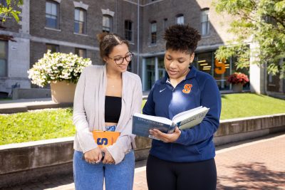 two students looking at a textbook