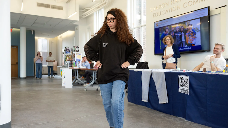 An InclusiveU student models some clothing