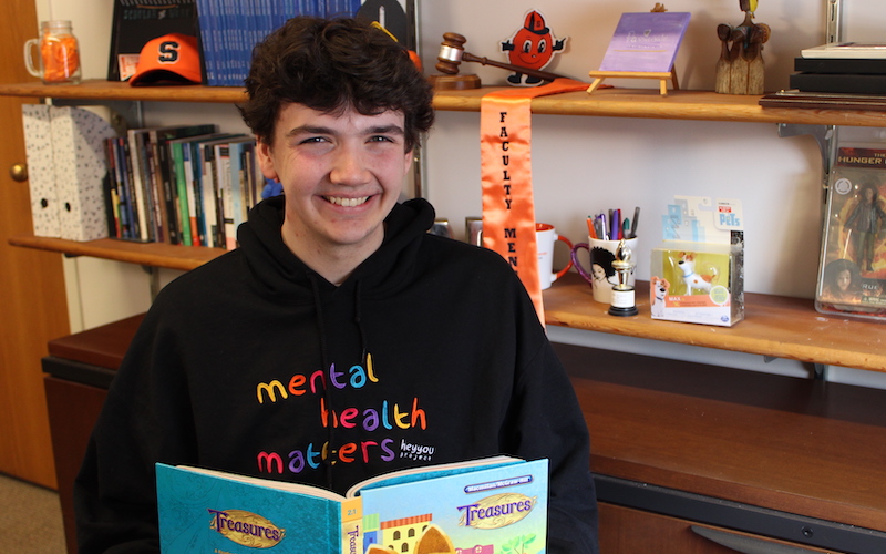 Jack Withee seated with a children's book