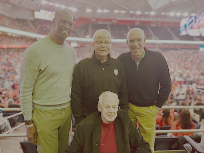 Four retired basketball players stand together