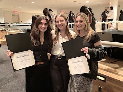 Three students pose with an award