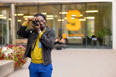 A man takes a photo while having his photo taken