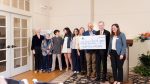 A group of people holding a large check