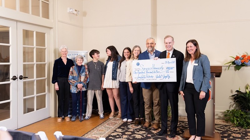 A group of people holding a large check