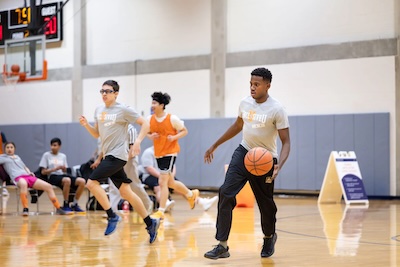 Two students play basketball