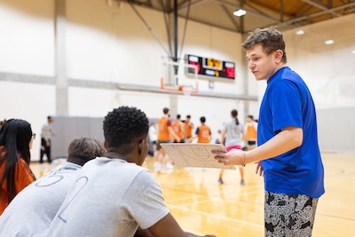 A basketball coach chats to his bench