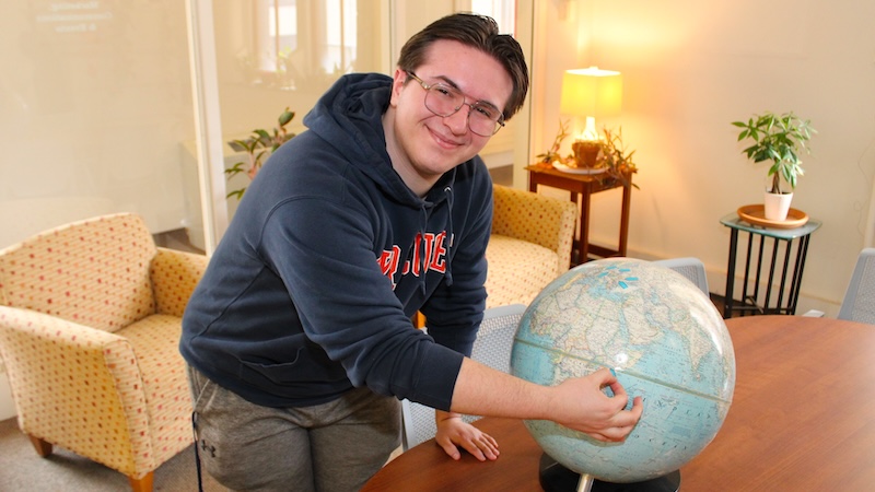 Mason Burley ponts at a globe