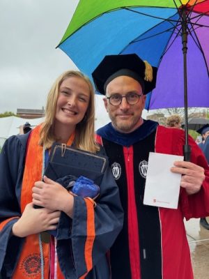 A professor and student pose with an award