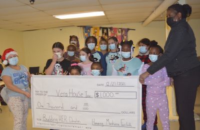 Moshiena Faircloth and her young students hold an oversized check for Vera House