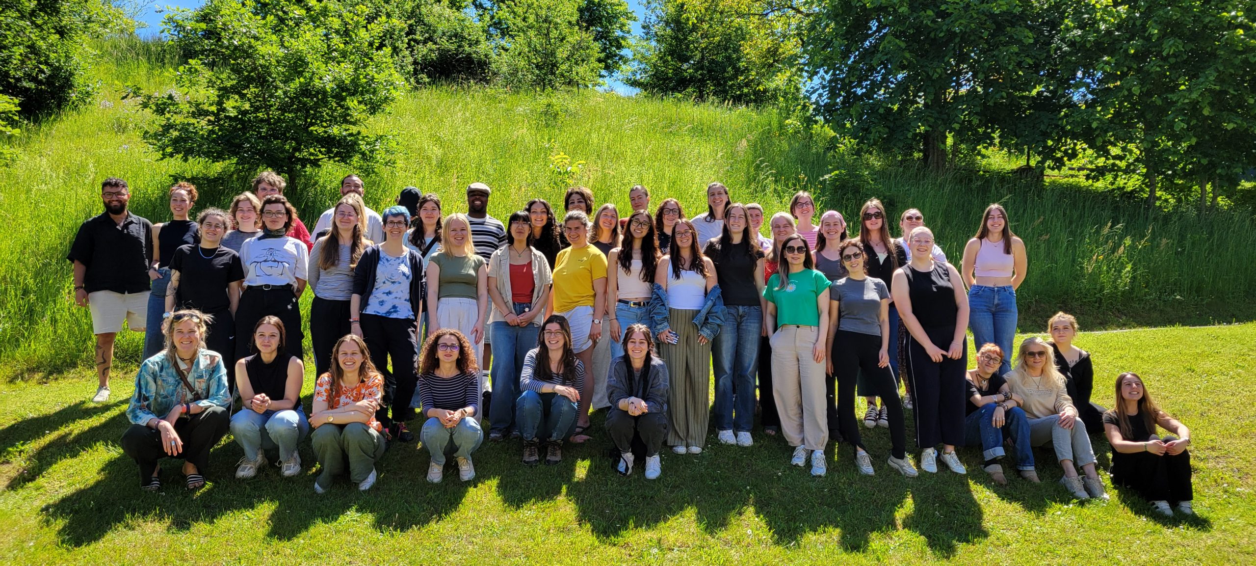 A large group of students stand in a field