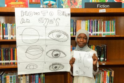 Young student holding poster.