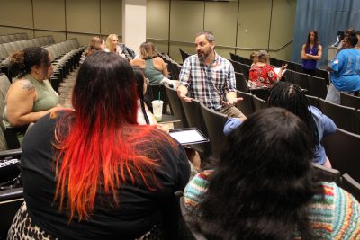 A professor chats to a group of teachers at a conference