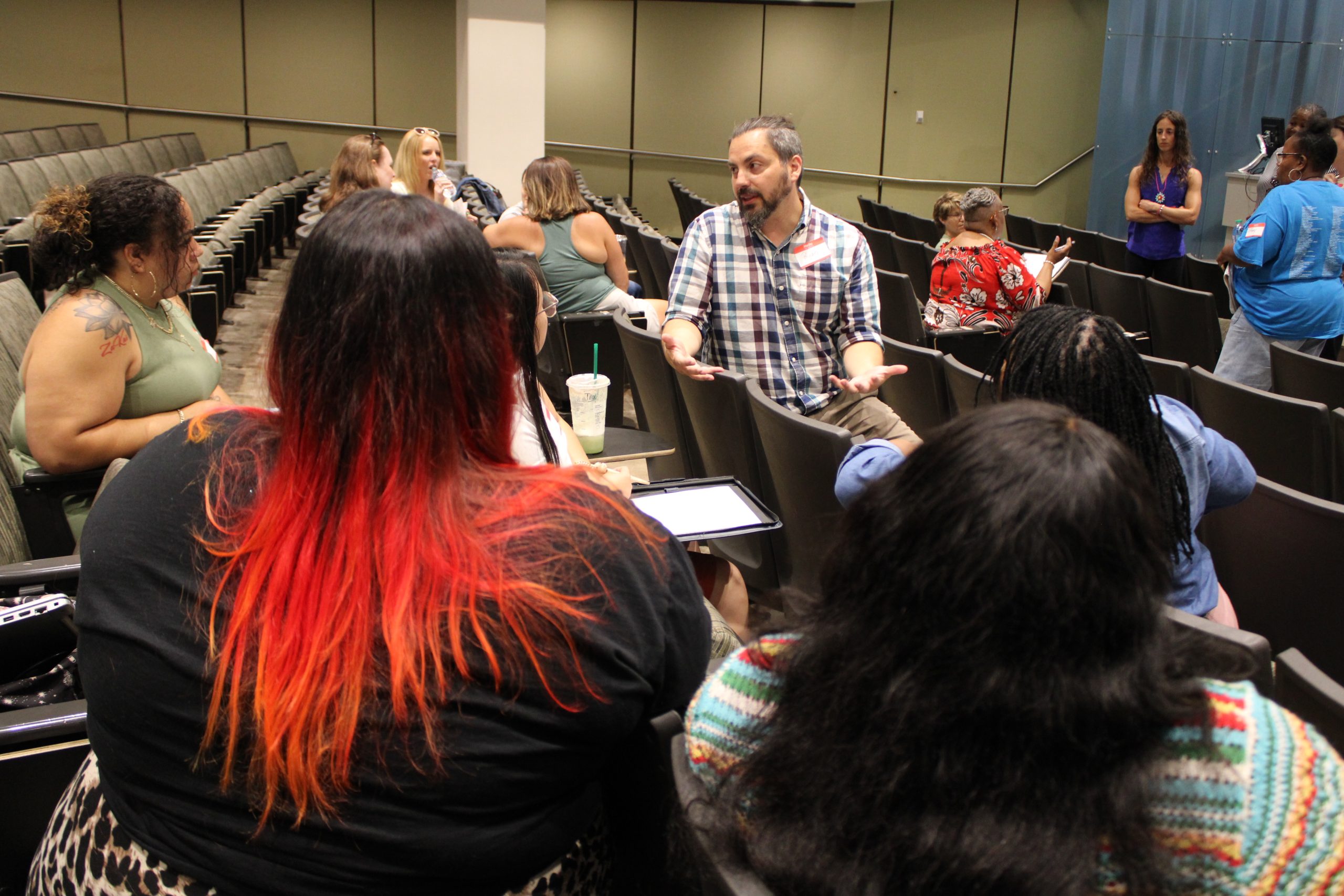 A professor chats to a group of teachers at a conference