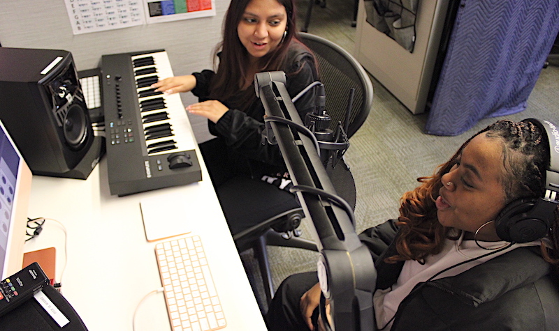 Two students of color at a digital music making station in the SENSES lab