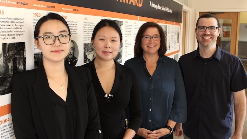 Four faculty members stand together