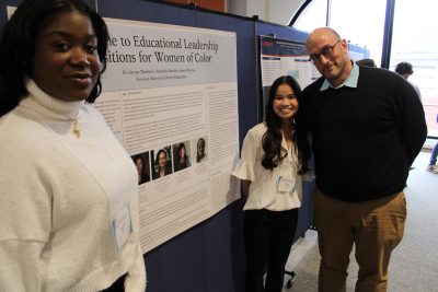 Students and professor around poster board