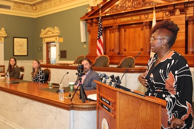 A professor leads a panel discussion from a podium