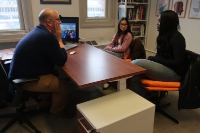 Professor and students around a desk