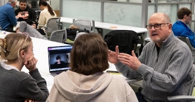 A teacher and students sit at a table