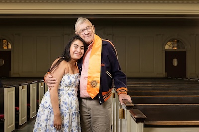 A grandfather and granddaughter pose together