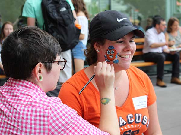 female stduent gets otto the orange painted on her face during a picnic