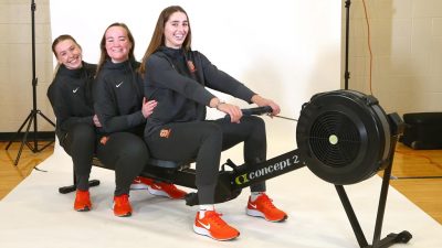 Lucy Pearce, Madeleine Holzman-Klima, and Maddy Horridge on a rowing machine