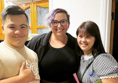 Graduate student standing with two students with disabilities. 