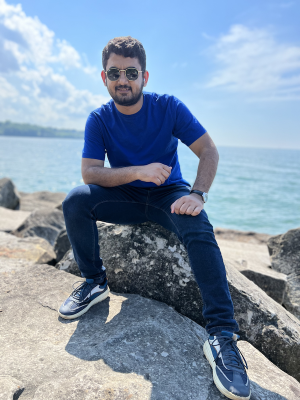 Image of Hafiz Awais Afzal sitting on a rock.